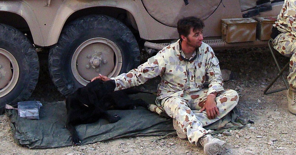 Craig finds a brief respite with his loyal companion amidst the harsh conditions of a desert deployment.